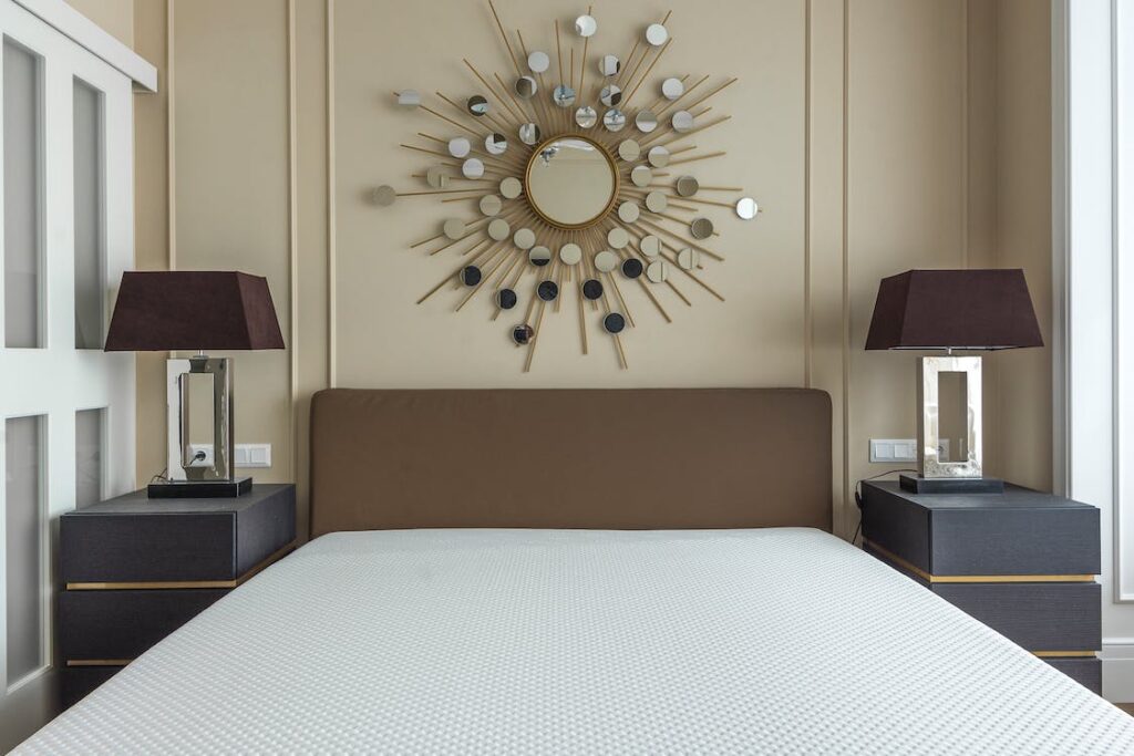 Choose the right mattress for your bedroom, like this brand-new one on a beige bed with a mirror above it. 