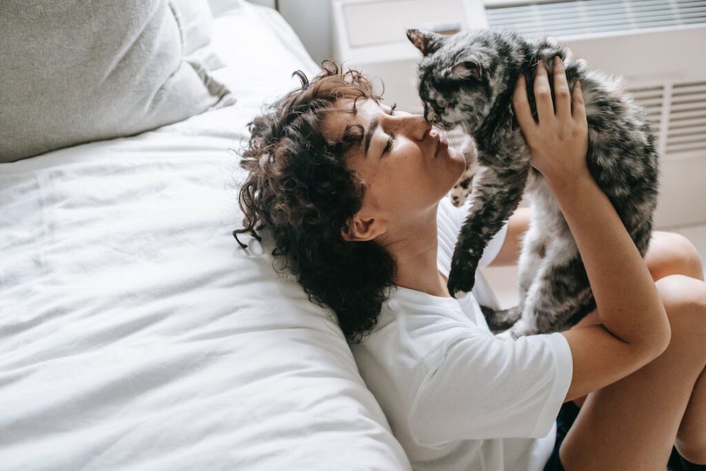 A woman holding her cat and thinking how your pet’s presence influences your sleep quality.